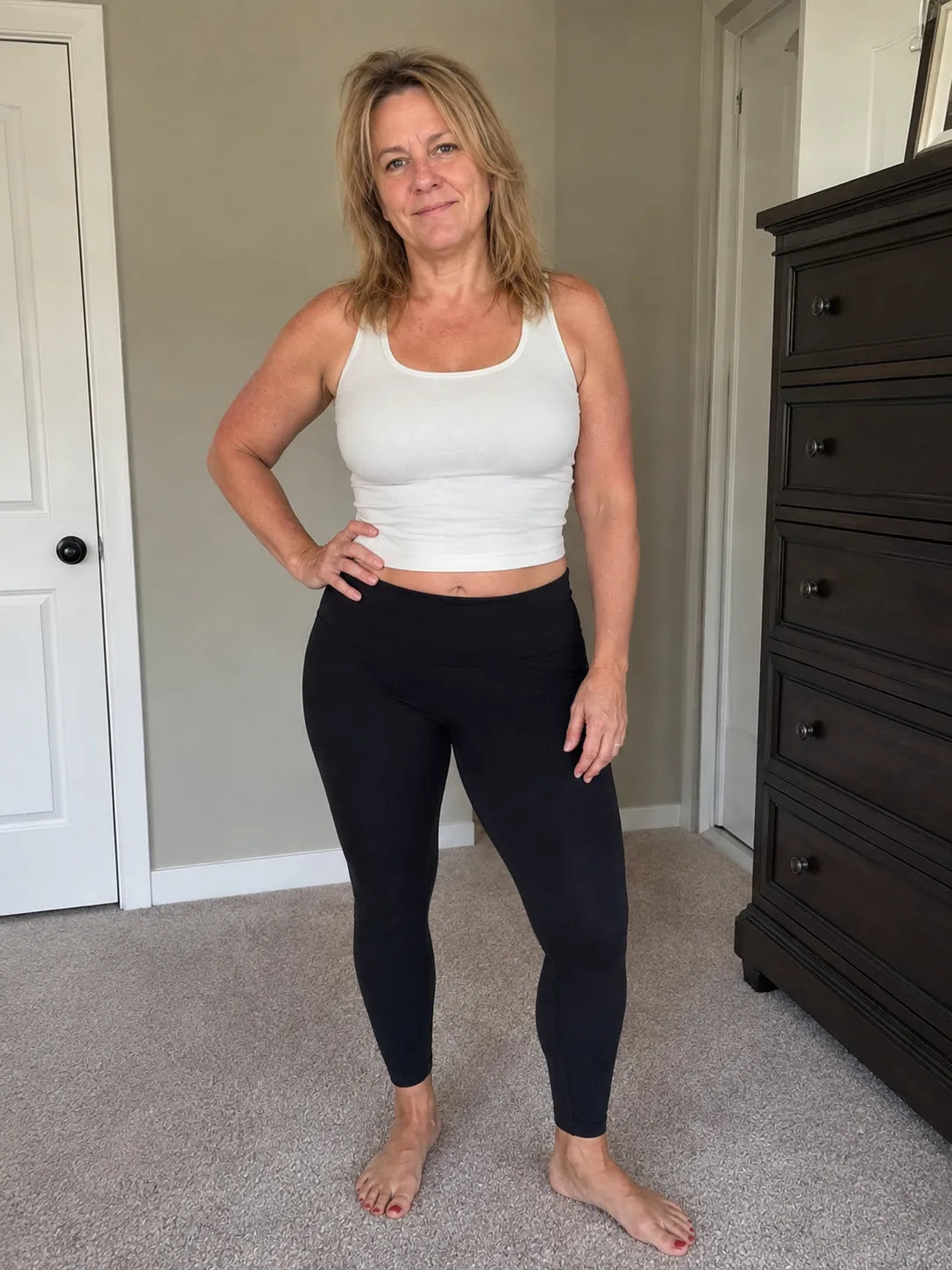 Woman standing indoors in white top